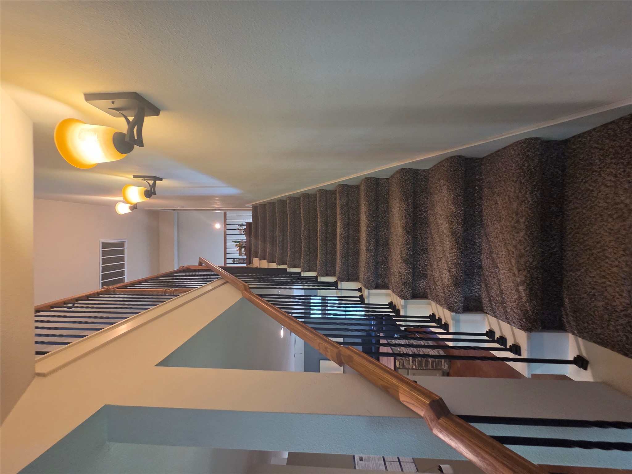 408 West Croslin Street Austin, TX 78752 - Photo 16 of 29 Ascend to the upper level on a gracefully curved staircase, illuminated by wall-mounted fixtures.