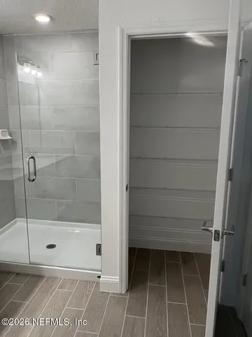 a bathroom with a shower a sink and mirror