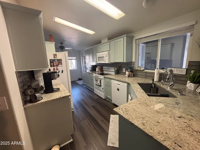 a kitchen with a sink stove top oven and cabinets