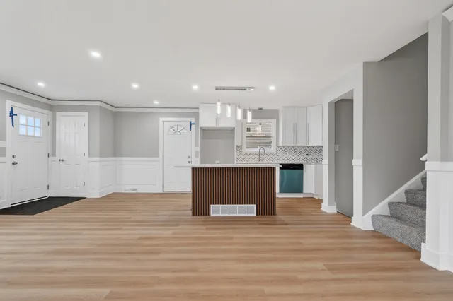 a view of kitchen and kitchen with granite countertop wooden floor