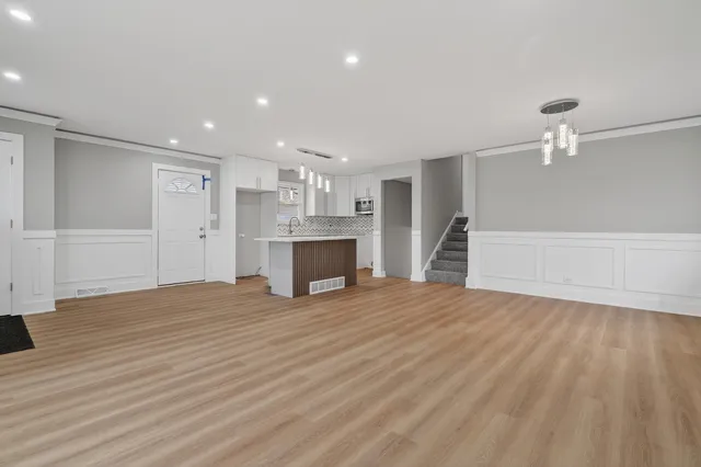 a view of empty room with wooden floor and fireplace