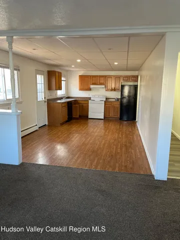 a large white room with kitchen view