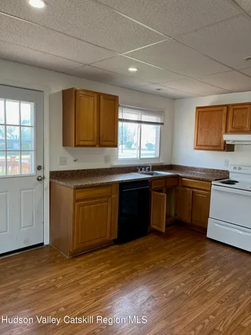 a kitchen with stainless steel appliances granite countertop a sink cabinets and wooden floor