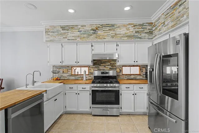 a kitchen with stainless steel appliances a stove sink and refrigerator