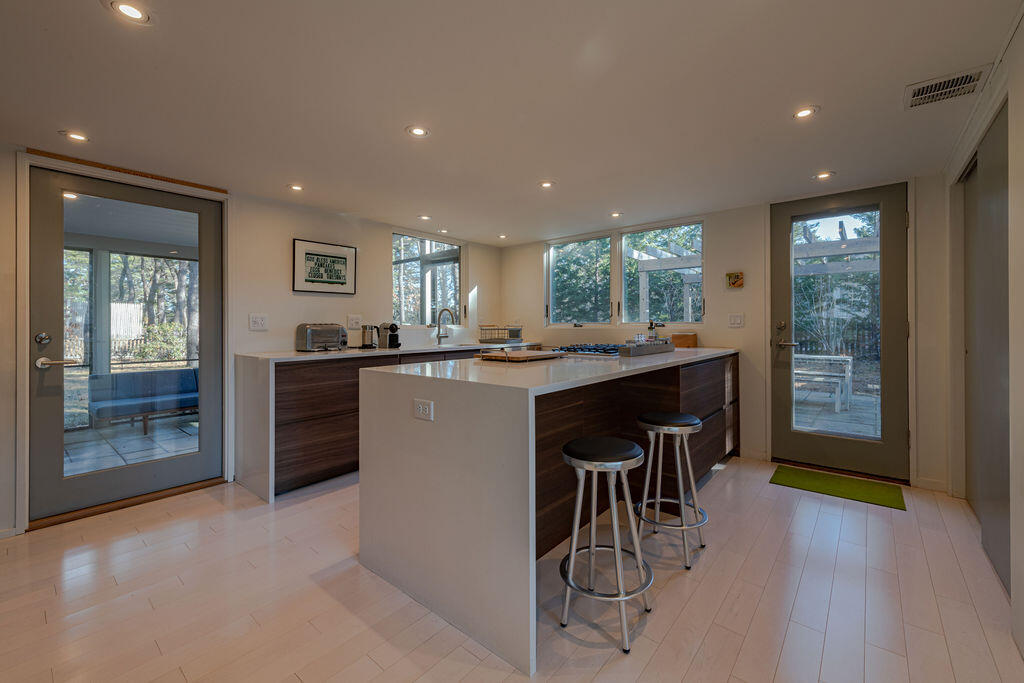 73 King Phillip Road Wellfleet, MA 02667 - Photo 4 of 35 a kitchen with stainless steel appliances granite countertop a refrigerator a sink a stove and a dining table with wooden floor