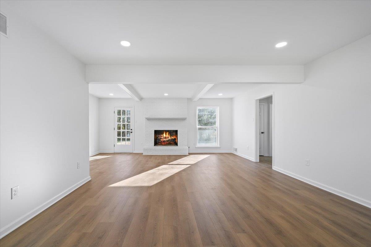 1676 Miller Farms Road Germantown, TN 38138 - Photo 9 of 37 Spacious living area featuring wood-finish flooring, recessed lighting, and a white brick fireplace with a mantle