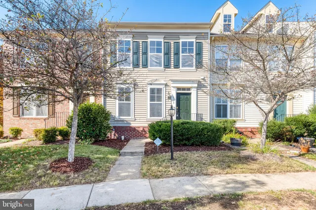 a front view of a house with garden and plants
