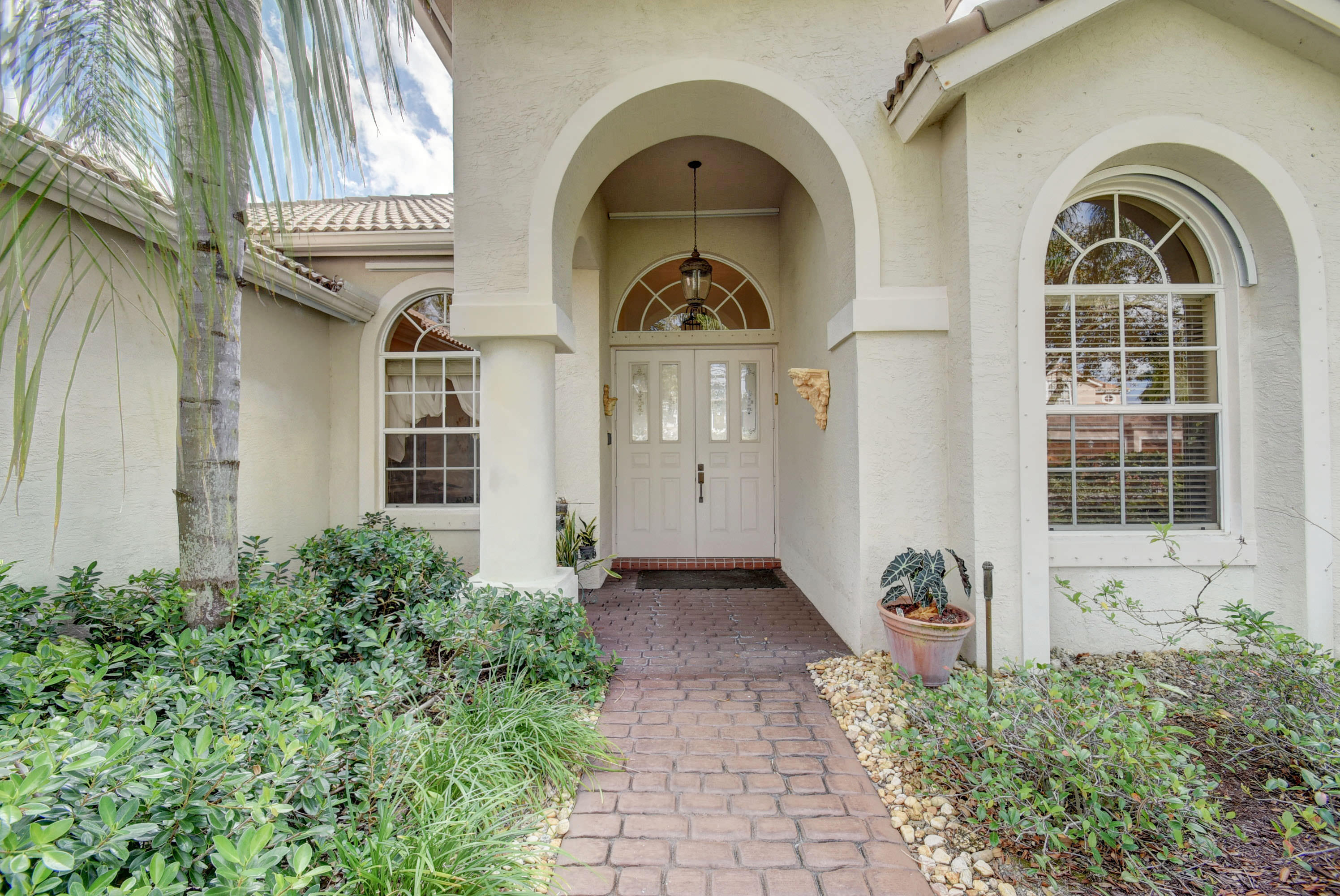 21587 Halstead Drive Boca Raton, FL 33428 - Photo 3 of 53 a view of a brick house with potted plants