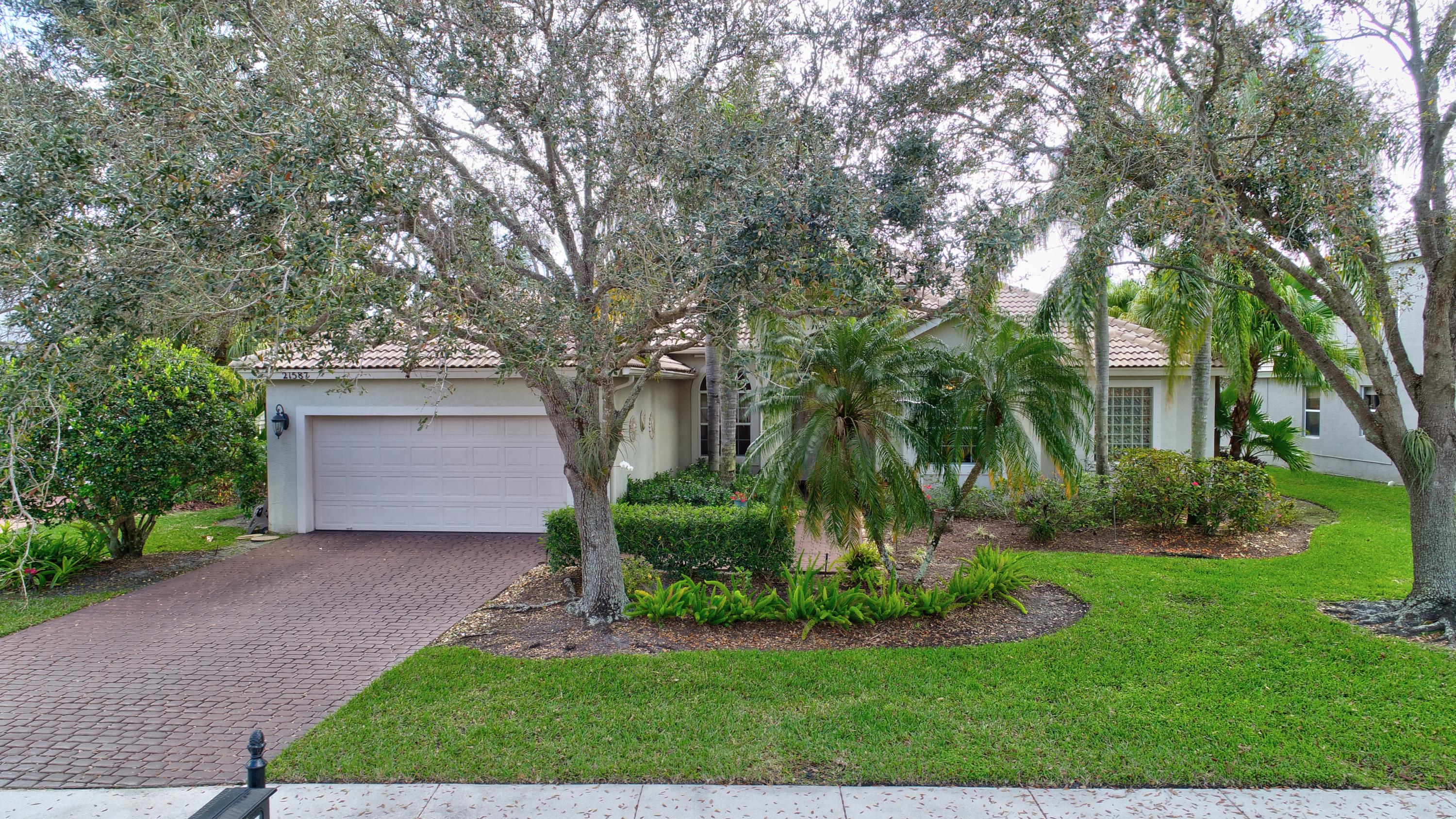 21587 Halstead Drive Boca Raton, FL 33428 - Photo 39 of 53 a front view of a house with a garden and tree