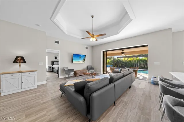 a living room with furniture kitchen view and a chandelier