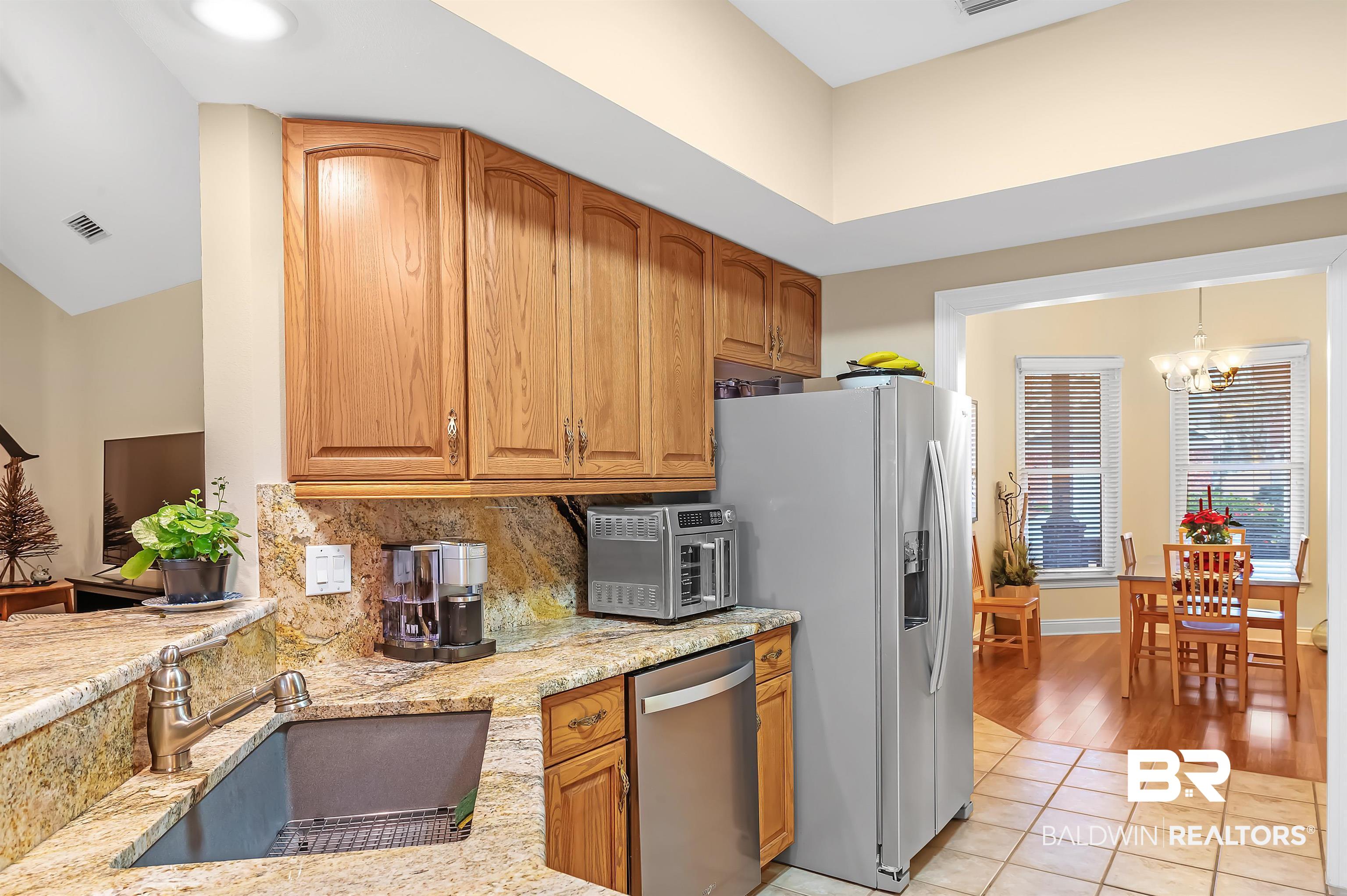 22726 Inverness Way Foley, AL 36535 - Photo 26 of 51 Kitchen featuring sink, stainless steel appliances, light stone counters, a chandelier, and light tile patterned floors