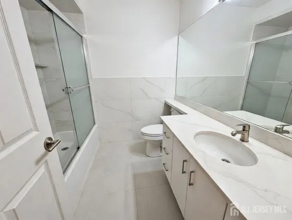 a bathroom with a double vanity sink toilet and shower