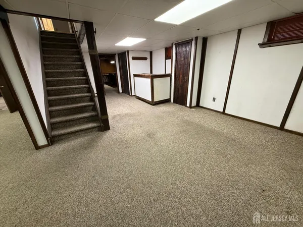 a view of an empty room with stairs and furniture