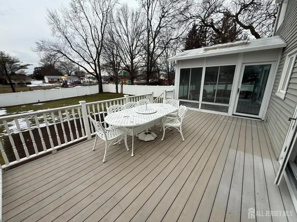a view of a roof deck with table and chairs wooden floor and fence