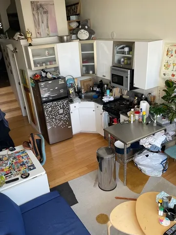 a kitchen with a stove and wooden floor