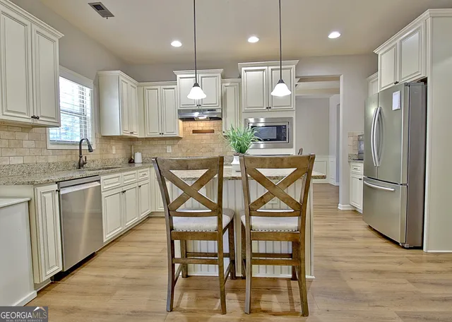 a view of a dining room with furniture a chandelier and wooden floor