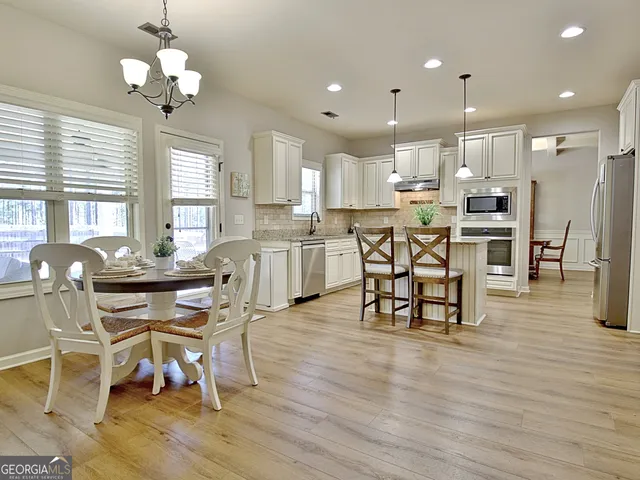 a kitchen with kitchen island granite countertop a sink a counter space appliances and cabinets