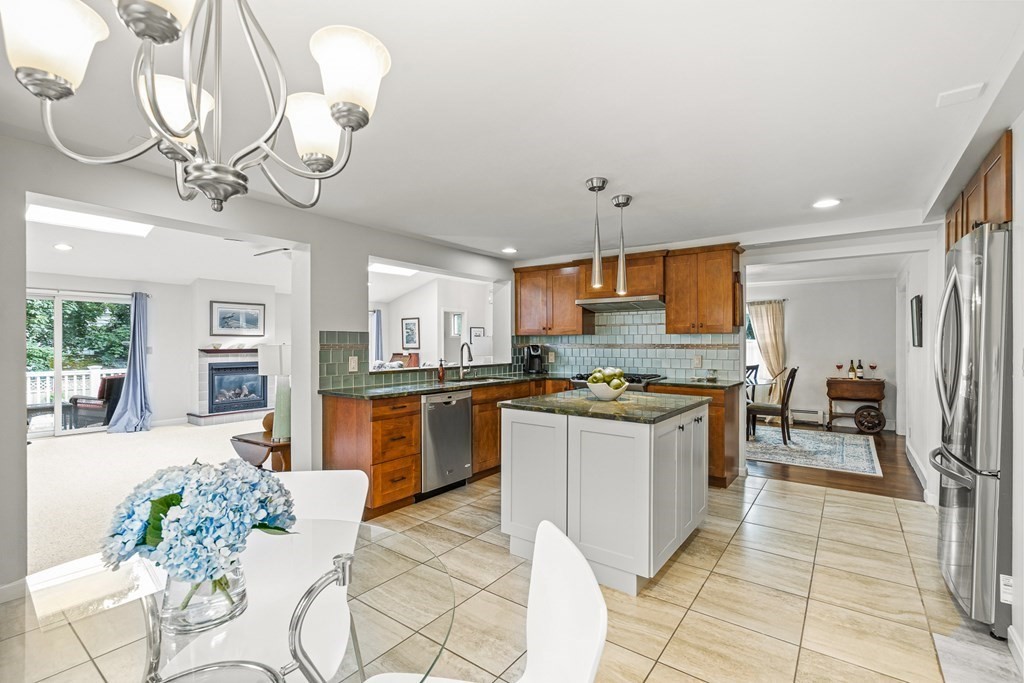 3 Laird Road Medford, MA 02155 - Photo 5 of 42 a kitchen with stainless steel appliances granite countertop a sink a stove oven a refrigerator with a dining table and chairs