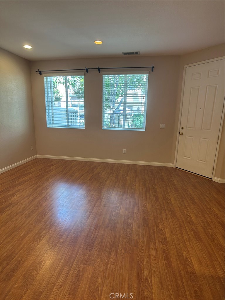 23 Cameron, Unit 67 Irvine, CA 92602 - Photo 4 of 15 an empty room with wooden floor and windows