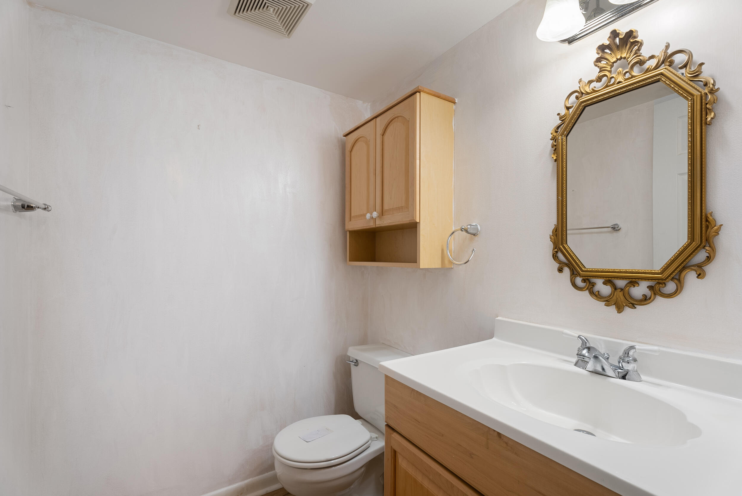 151 Southwest South River Drive, Unit 203 Stuart, FL 34997 - Photo 13 of 54 a bathroom with a toilet a sink and mirror