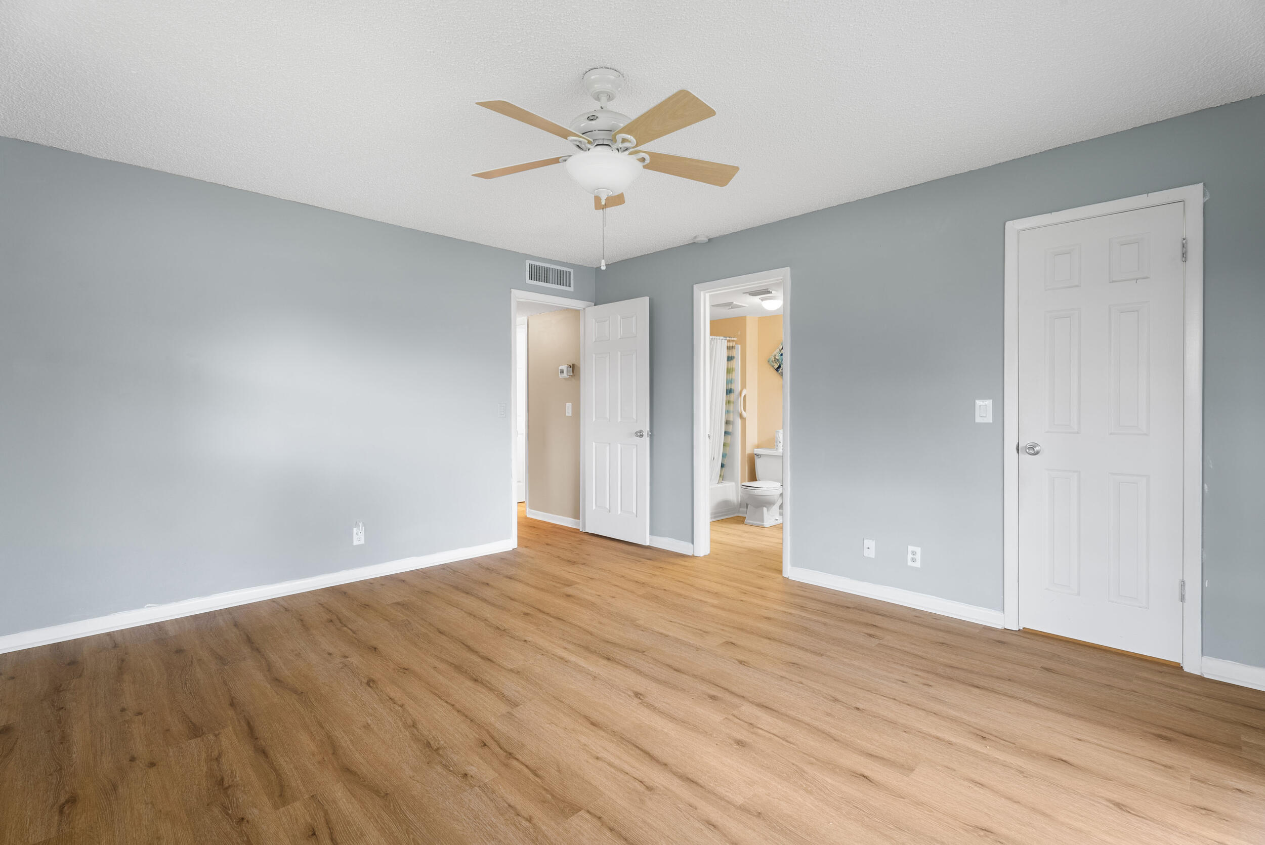 151 Southwest South River Drive, Unit 203 Stuart, FL 34997 - Photo 16 of 54 an empty room with wooden floor and ceiling fan