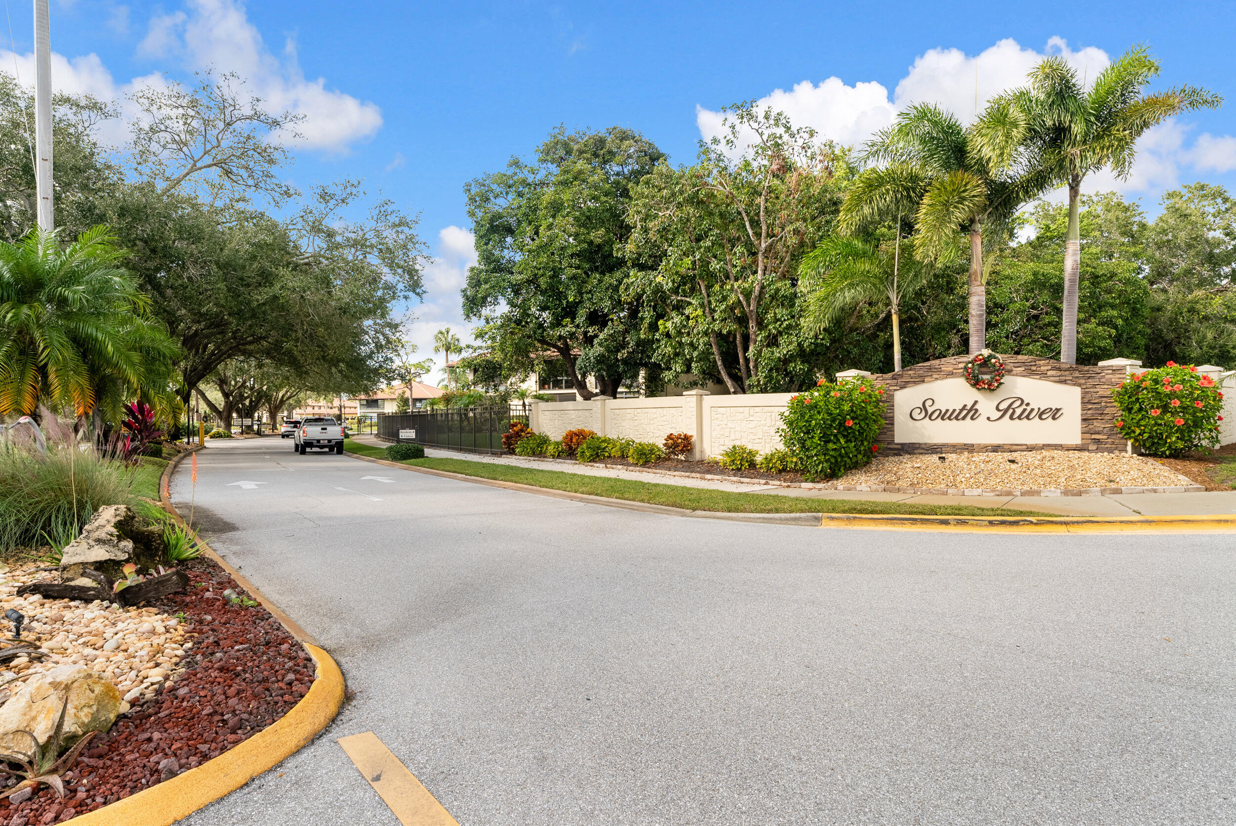 151 Southwest South River Drive, Unit 203 Stuart, FL 34997 - Photo 2 of 54 a view of a swimming pool with some potted plants and large trees