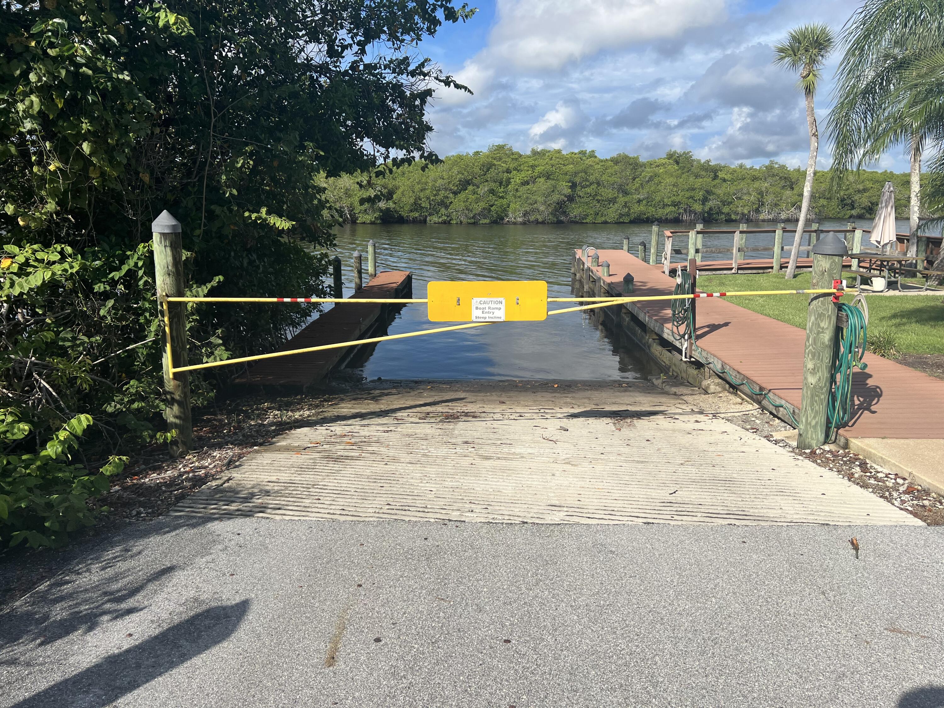 151 Southwest South River Drive, Unit 203 Stuart, FL 34997 - Photo 49 of 54 a view of a swimming pool with a lounge chair and a small yard