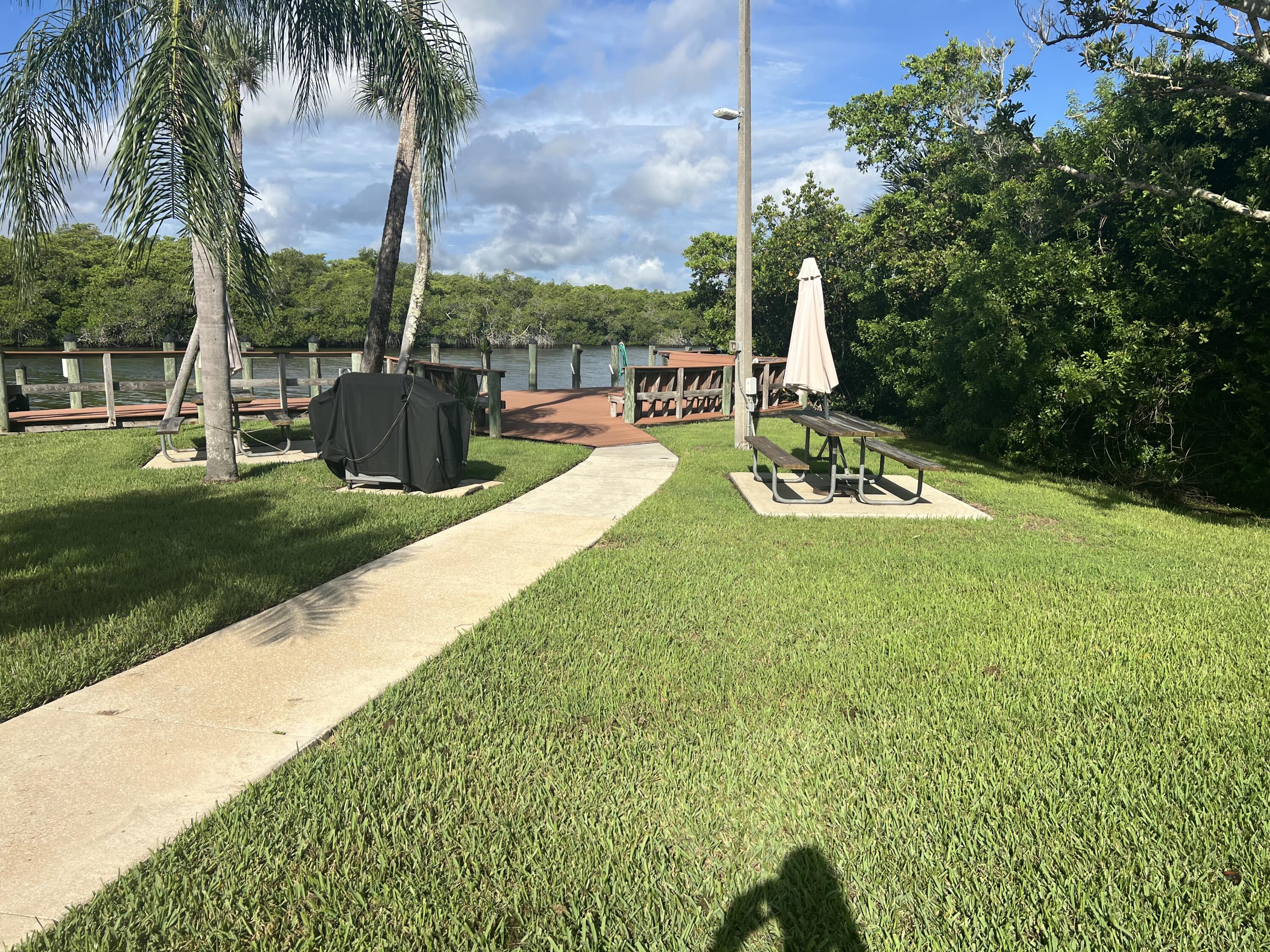 151 Southwest South River Drive, Unit 203 Stuart, FL 34997 - Photo 50 of 54 a view of a swimming pool with a patio and a garden