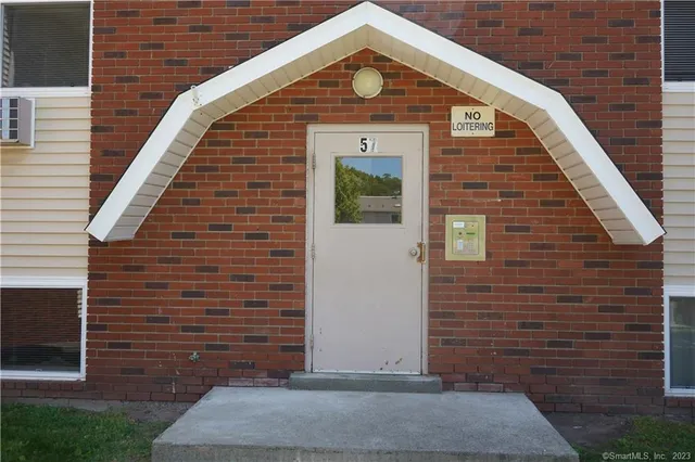 a view of brick house with wooden fence