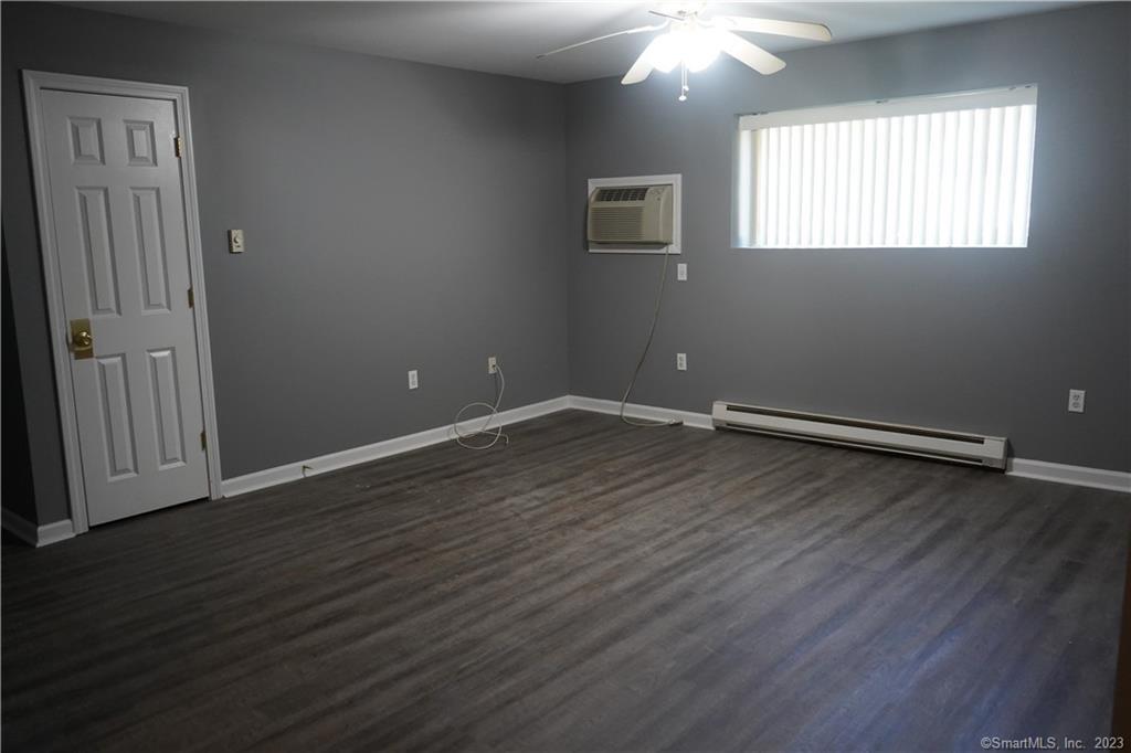 57 Glade Street, Unit A2 West Haven, CT 06516 - Photo 5 of 18 an empty room with wooden floor and windows