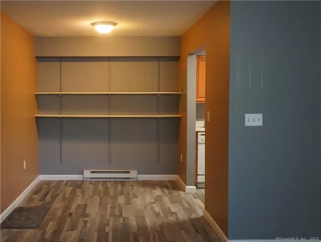 a view of an empty room with a wooden floor and a window