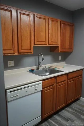 a kitchen with stainless steel appliances granite countertop a sink a stove and dishwasher with wooden cabinets