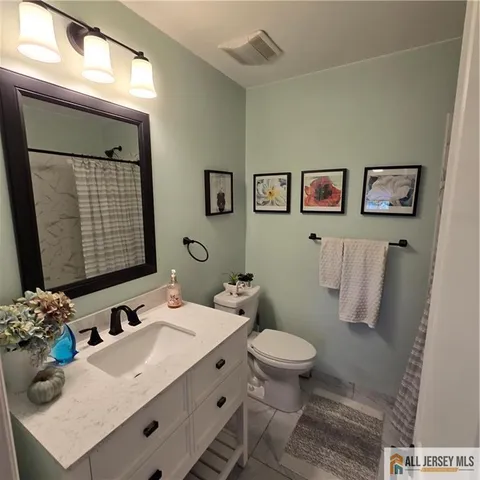 a bathroom with a sink mirror and toilet