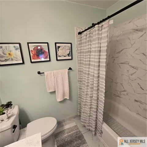 a bathroom with a toilet and a shower curtain