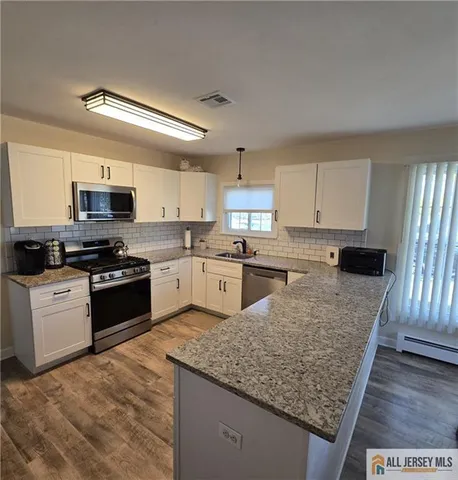 a kitchen with stainless steel appliances granite countertop a stove sink and cabinets