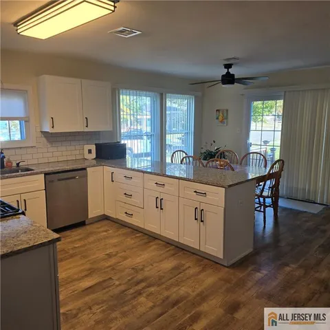 a kitchen with white cabinets and sink
