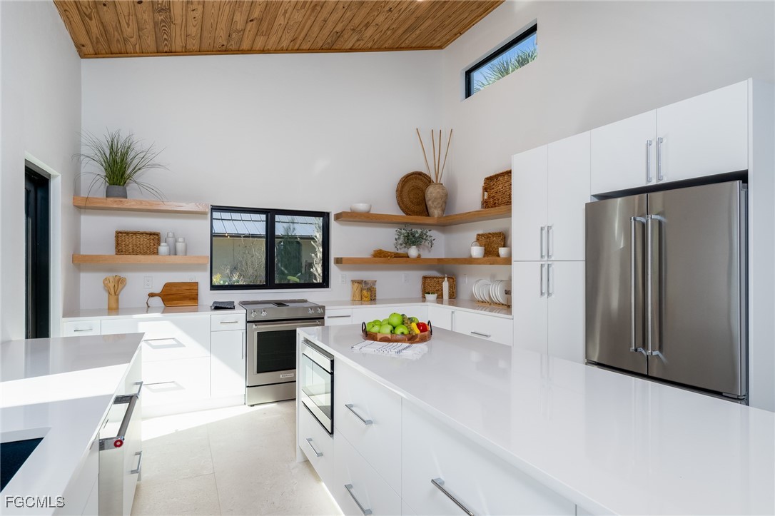5801 Sanibel Captiva Road Sanibel, FL 33957 - Photo 21 of 45 a kitchen with a refrigerator a stove and a wooden floor