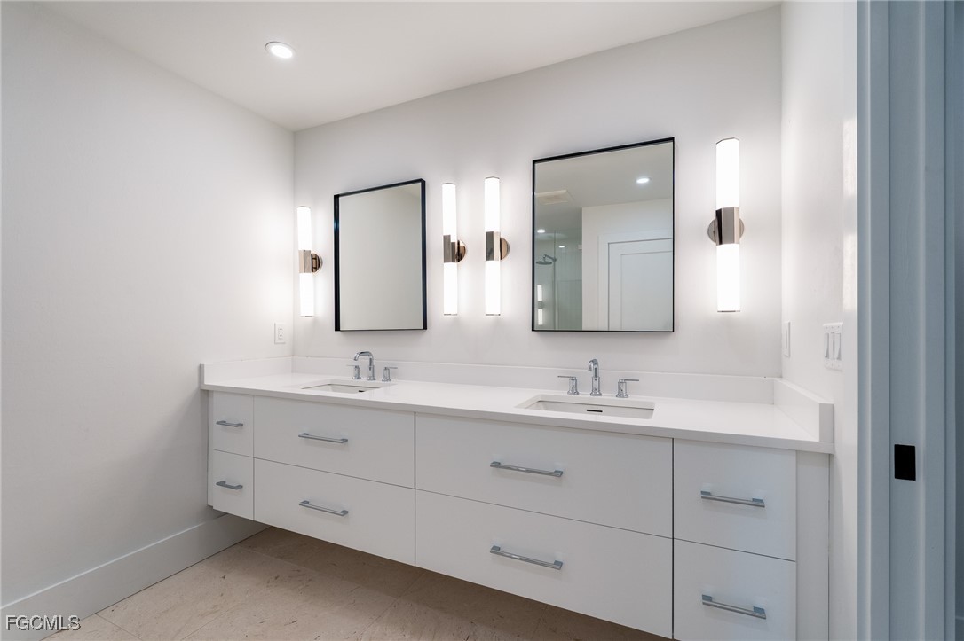 5801 Sanibel Captiva Road Sanibel, FL 33957 - Photo 25 of 45 a bathroom with a double vanity sink and mirror