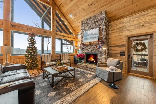 a living room with furniture a fireplace and a floor to ceiling window