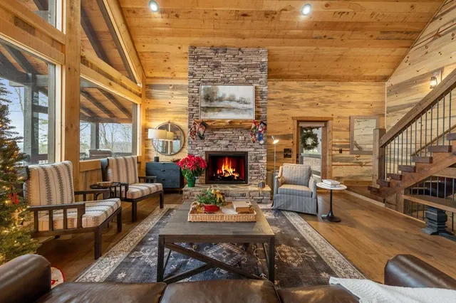 a living room with furniture large window and a fireplace