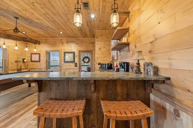 a room with pool table and windows with wooden floor