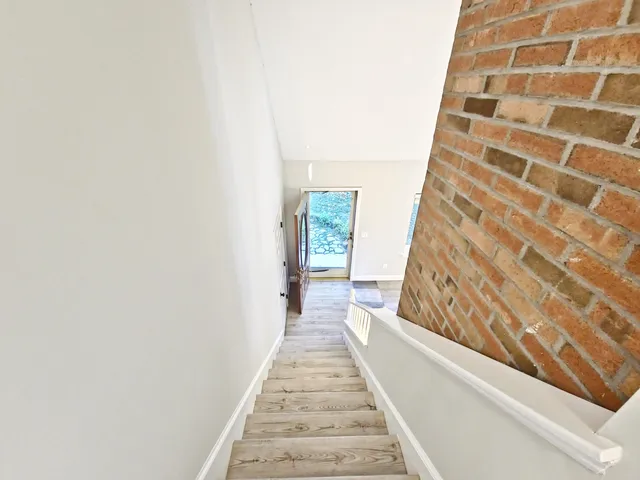 a view of a hallway with wooden floor and a large window