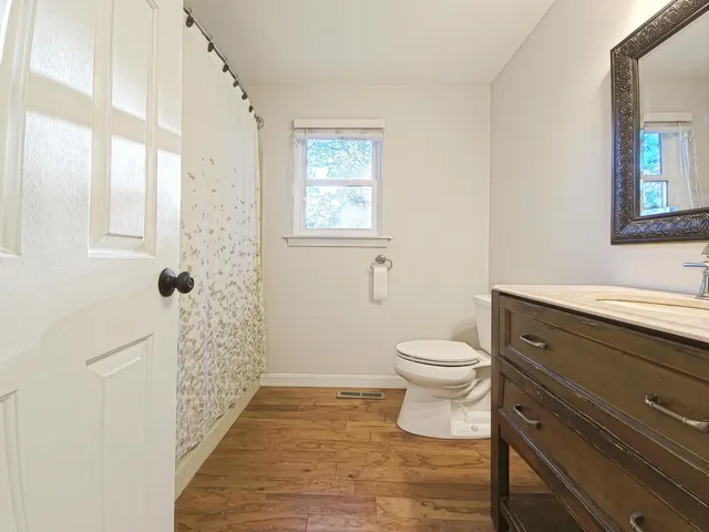 a bathroom with a sink a toilet and shower