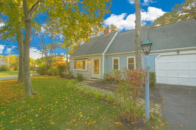 a view of a yard in front of a house with large tree