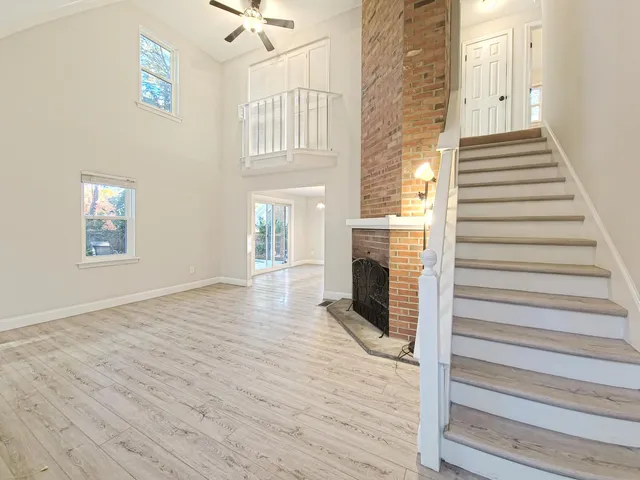 a view of a livingroom with wooden floor a fireplace and entryway