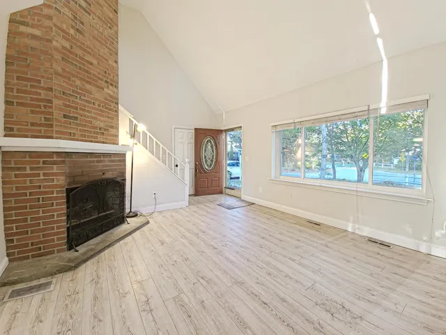 a view of empty room with wooden floor and fireplace