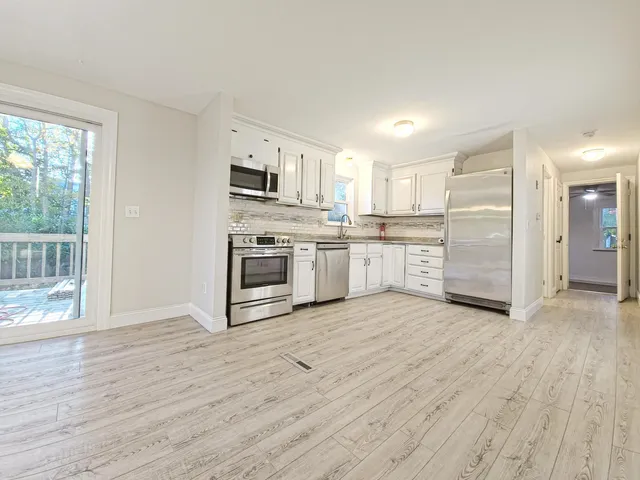 a view of kitchen with wooden floor and electronic appliances