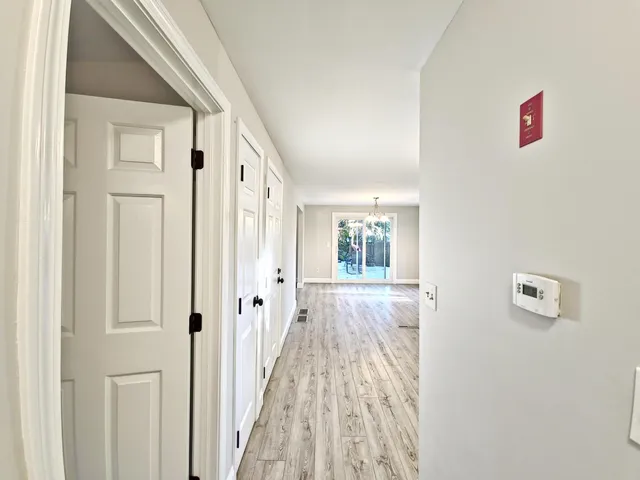 a view of a hallway with wooden floor and windows