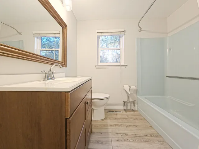 a bathroom with a double vanity sink toilet and a bathtub