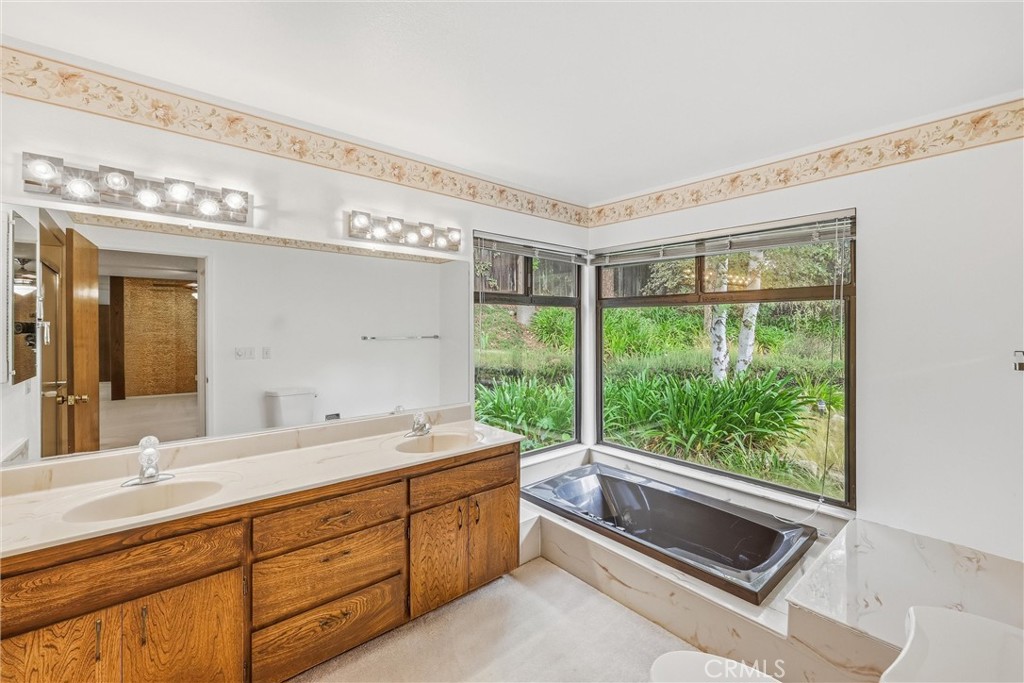 37295 Oak View Road Yucaipa, CA 92399 - Photo 34 of 59 a spacious bathroom with a double vanity sink and a large mirror